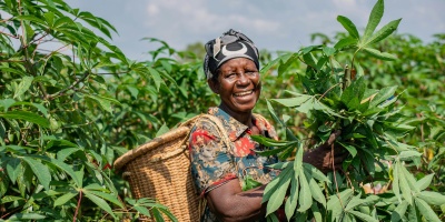 Woman smiling in an agricultural field. Photo by Safari Consoler via Pexels