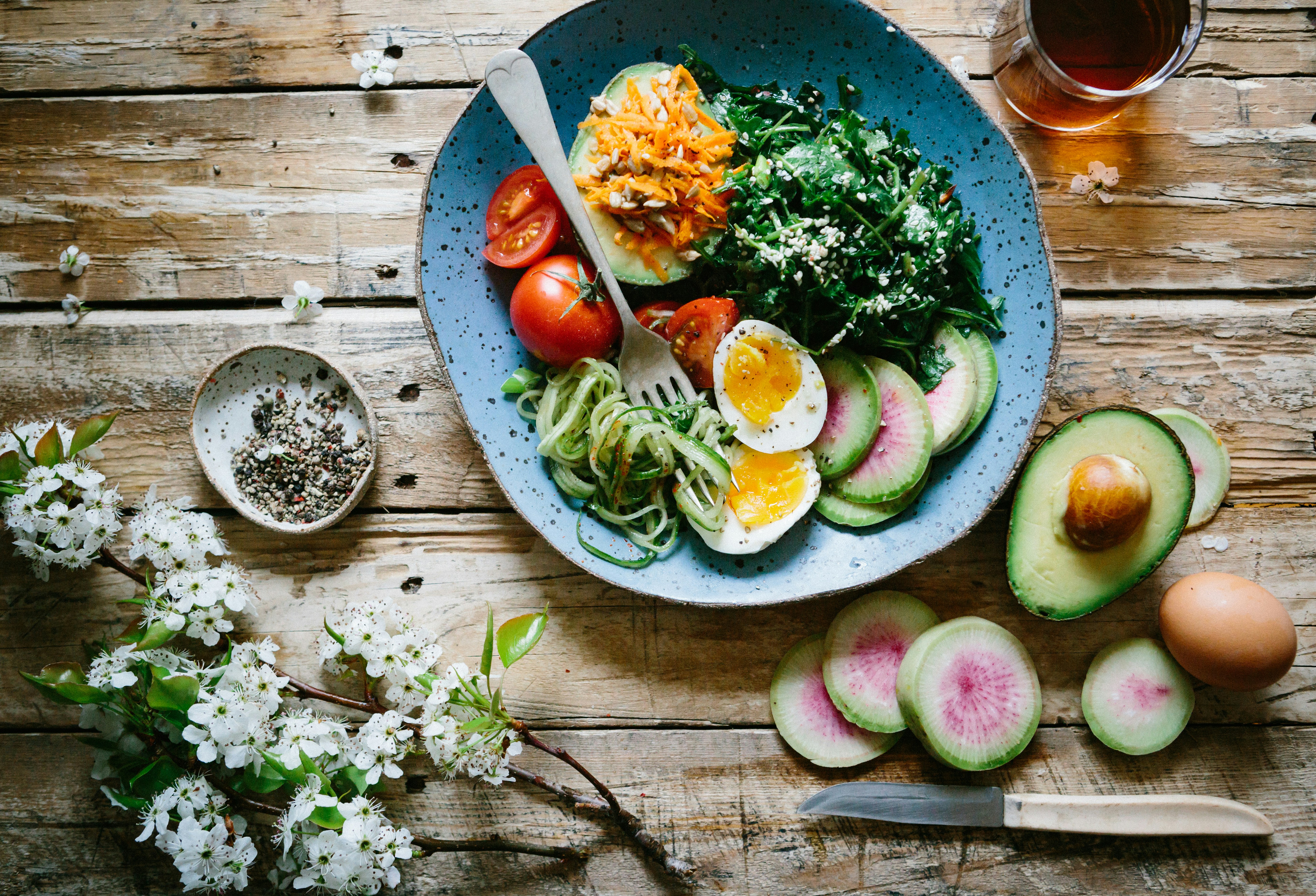 A blue plate with salad and other vegetables. Photo by Brooke Lark via Unsplash.