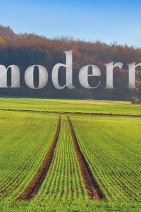 A field with tractor tracks through the middle extends into the distance, with a forest in the distance. The text asks "What is ecomodernism?"