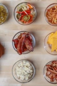 Charcuterie plate with mustards, cheeses, fruits, relishes, bacon, and breads. Tim Toomey via Unsplash.