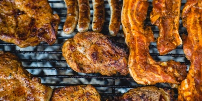 Chicken, bacon, and sausages cooked on a barbeque. Photo by Marcus Spiske via Unsplash.