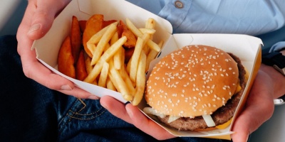 Photo of a burger and chips in single use packaging. Photo by ready made via Pexels.