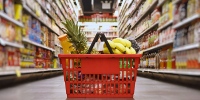 A shopping basket full of fruit in the middle of a grocery store. Image via Cornell University