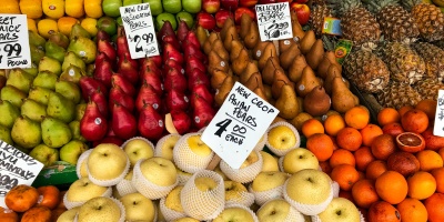 A market stall with apples, pears, oranges and pineapples. Photo by Rajiv Perera via Unsplash