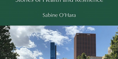 Front cover of the book “Food Justice in American Cities” (2023) with photo of an urban garden with large buildings in the background.