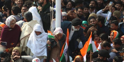 Image: Protester’s surrounding a pole holding Indian flags. Photo by Shakeb Tawheed via Pexels