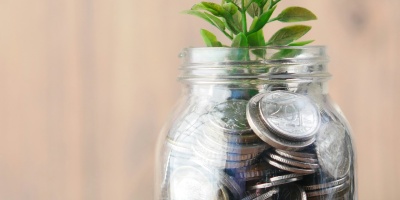 Image: A glass filled with silver coins and a plant on top. Image by Towfiqu bharbuiya via unsplash