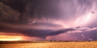 Photo of a storm over a field of wheat.