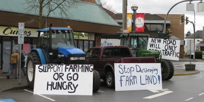 Image: Tractors with protest signs in the street. Photo by stopthepave via flickr