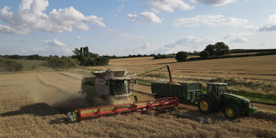 Combine harvester and tractor in field of wheat