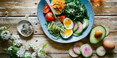 A blue plate with salad and other vegetables. Photo by Brooke Lark via Unsplash.