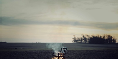 Burning chair in field. Credit: Carolina Basi via Pexels