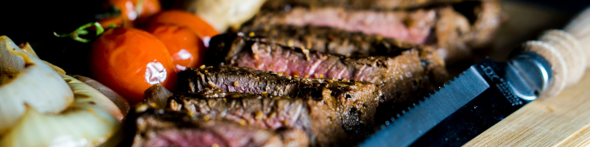 A steak and vegetables on a cutting board. Photo by Amirali Mirhashemian via Unsplash.