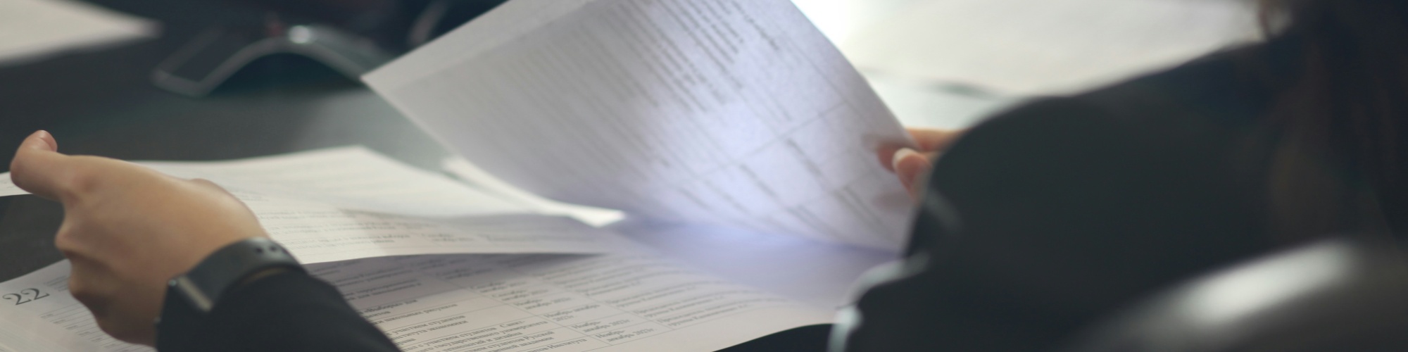 A woman shuffles through documents. Photo by Anastassia Anufrieva via Unsplash.