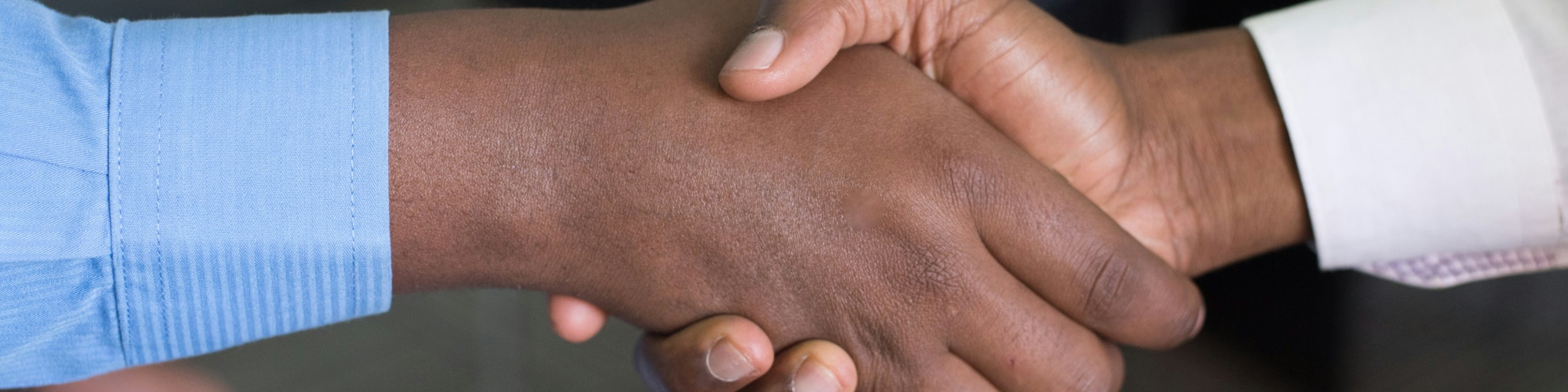 Two people shake hands. Photo by Cytonn Photography via Unsplash.