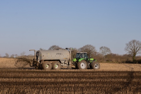 Tractor spreading fertiliser on field. Photo by Mirko Fabian via Pexels.
