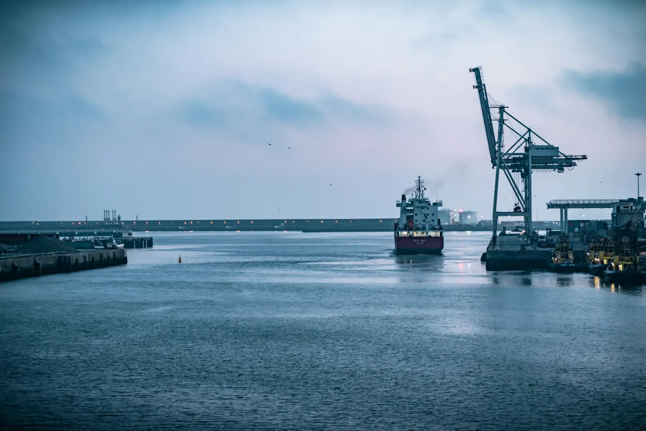 A cargo ship arriving into a port. Photo by Maksym Kaharlytskyi via Unsplash.