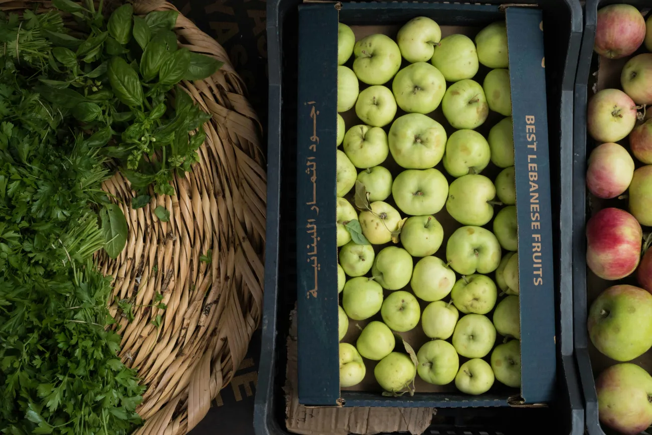 Baskets of apples and green leafy vegetables. Photo by Peter F via Unsplash.