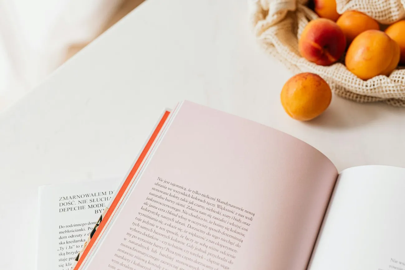 Oranges next to book. Credit: Karola G via Pexels.