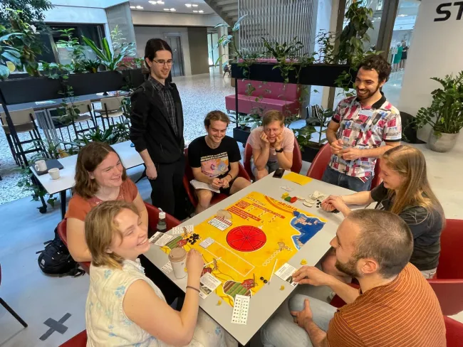 Provided by Frederico Andreotti for his Essay on Games on TABLE, pictures a group playing the student game 'Aridia', sent 30 April 2025