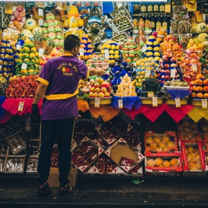 Photo of food market trader in São Paulo. Photo by D A V I D S O N L U N A via Unsplash