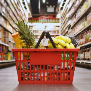 A shopping basket full of fruit in the middle of a grocery store. Image via Cornell University