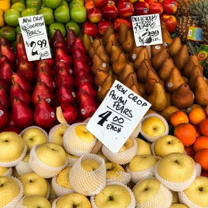 A market stall with apples, pears, oranges and pineapples. Photo by Rajiv Perera via Unsplash