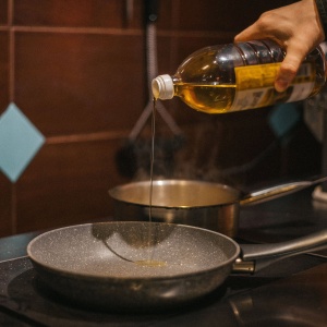 Photo of cooking oil being poured into a pan. Image by Max Avans via Pexels