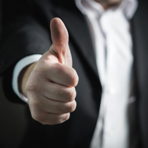 Photo of someone in a suit with thumbs up. Credit: Pixabay via Pexels