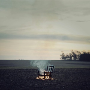 Burning chair in field. Credit: Carolina Basi via Pexels