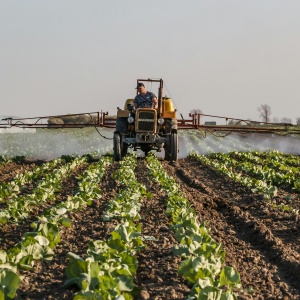 Photo of tractor with sprayer in field. Credit Stitch via Pexels